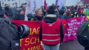 Desiree Becker im Gespräch mit einer Aktivistin, die ein fragwürdiges Banner trug